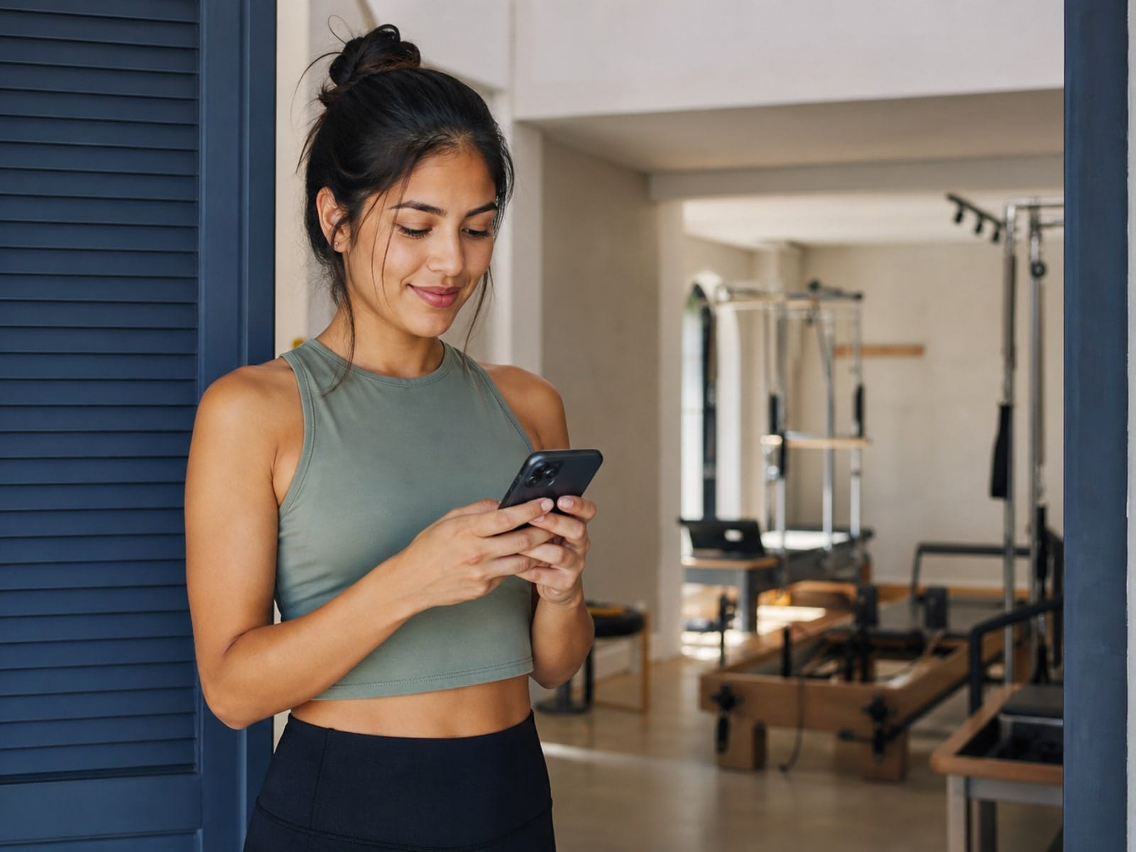 Aluna reservando aula de pilates pelo celular